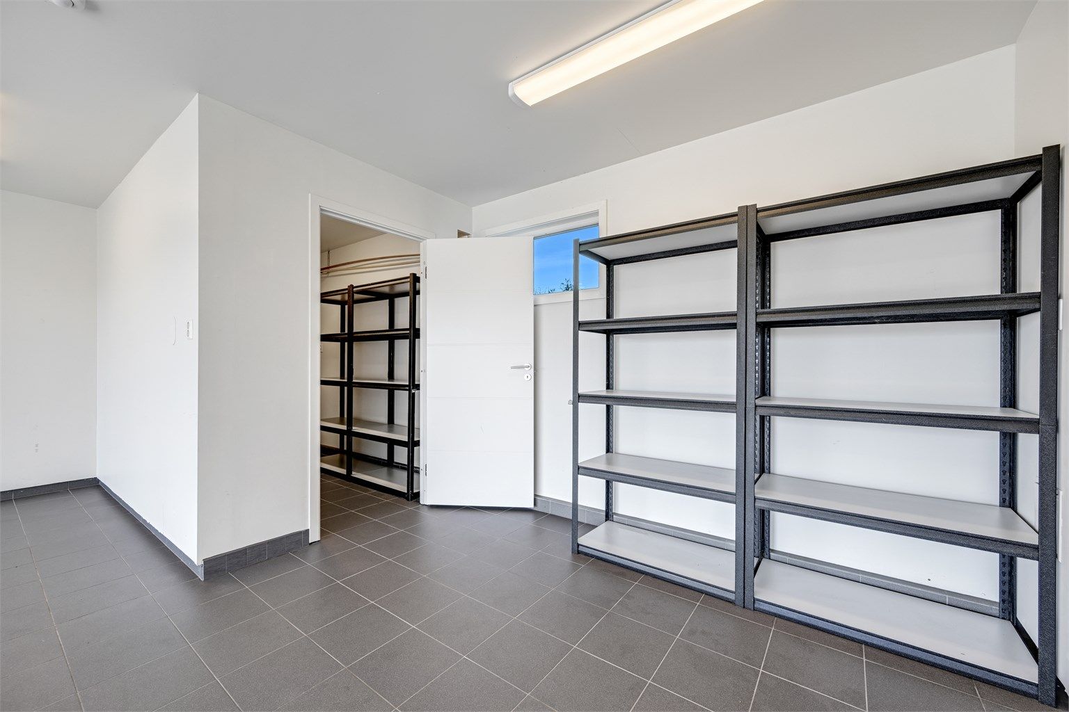 Inne i garasjen er det etablert en praktisk, separat bod for ekstra lagringsplass.