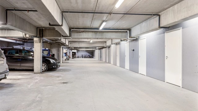 En parkeringsplass i felles garasjeanlegg. Det er montert elbillader på parkeringsplassen. Det følger med en bod rett ved p-plassen.