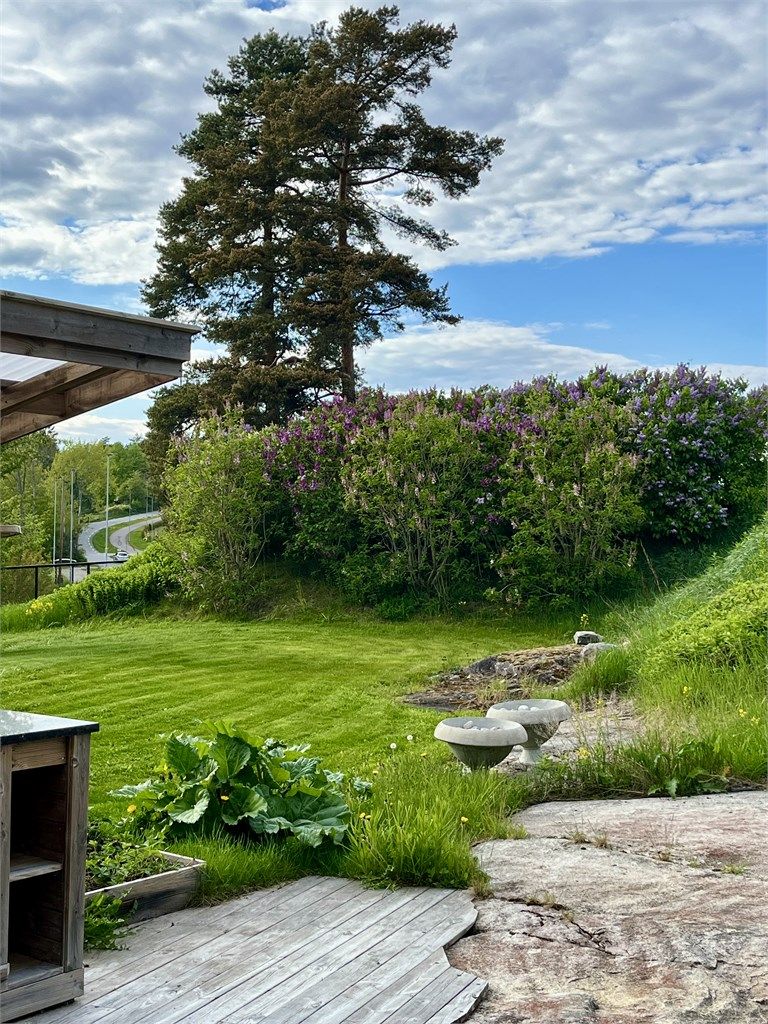 De blomstrende syrinbuskene skaper en frodig og innbydende ramme rundt uteområdet.