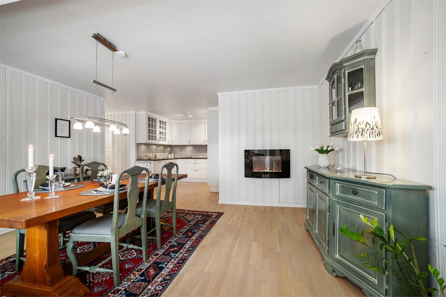  Den åpne planløsningen mellom kjøkken og spisestue skaper en praktisk overgang mellom sonene, og legger til rette for en sosial atmosfære.