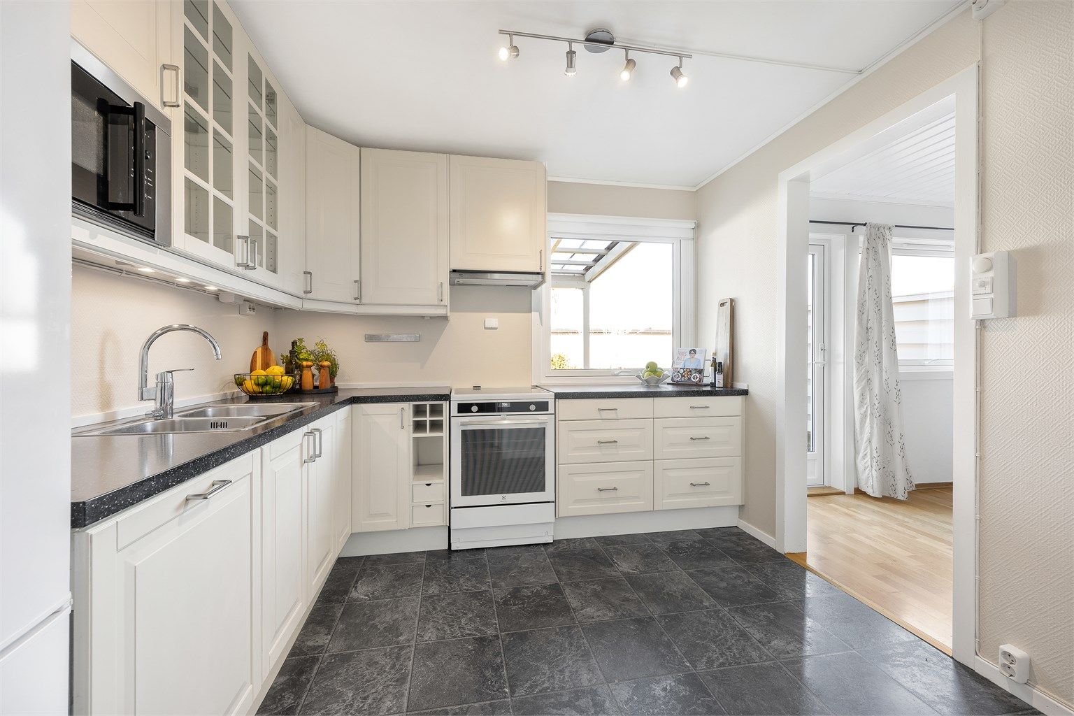 Belysning i taket og under overskapene sørger for godt arbeidslys på kjøkkenbenken.