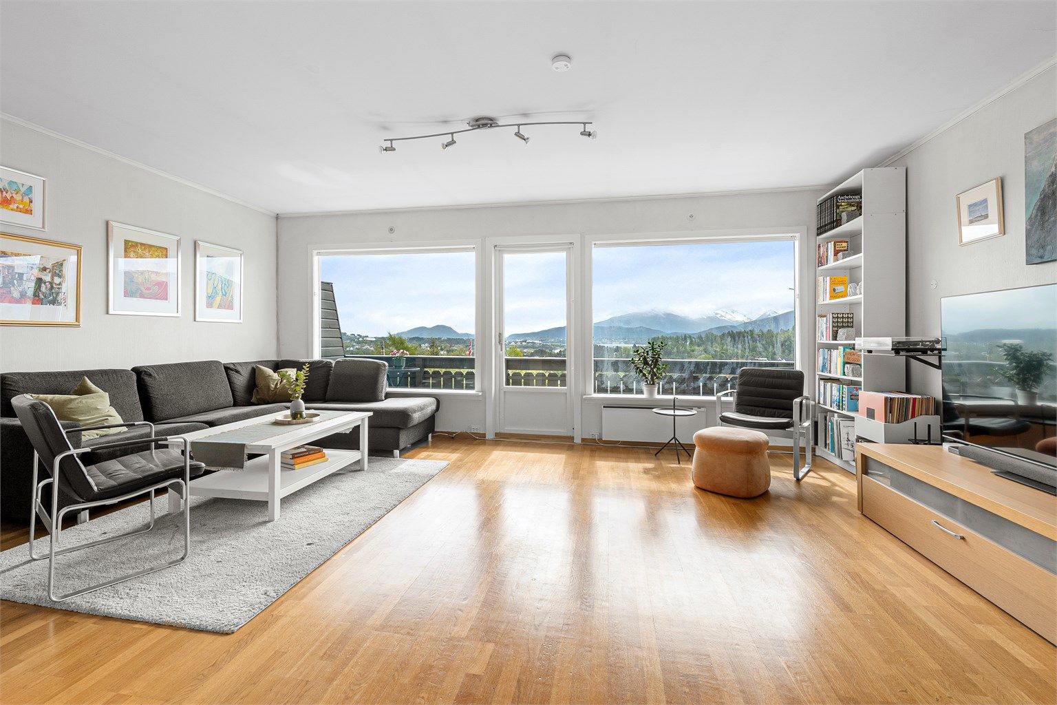 Stue med lyse overflater og store vinduer som gir godt med lysinnslipp