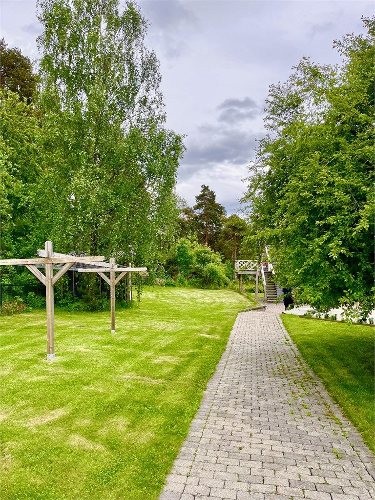 Du ankommer boligen via en pent opparbeidet brosteinsbelagt vei. 