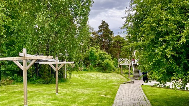 Du ankommer boligen via en pent opparbeidet brosteinsbelagt vei.