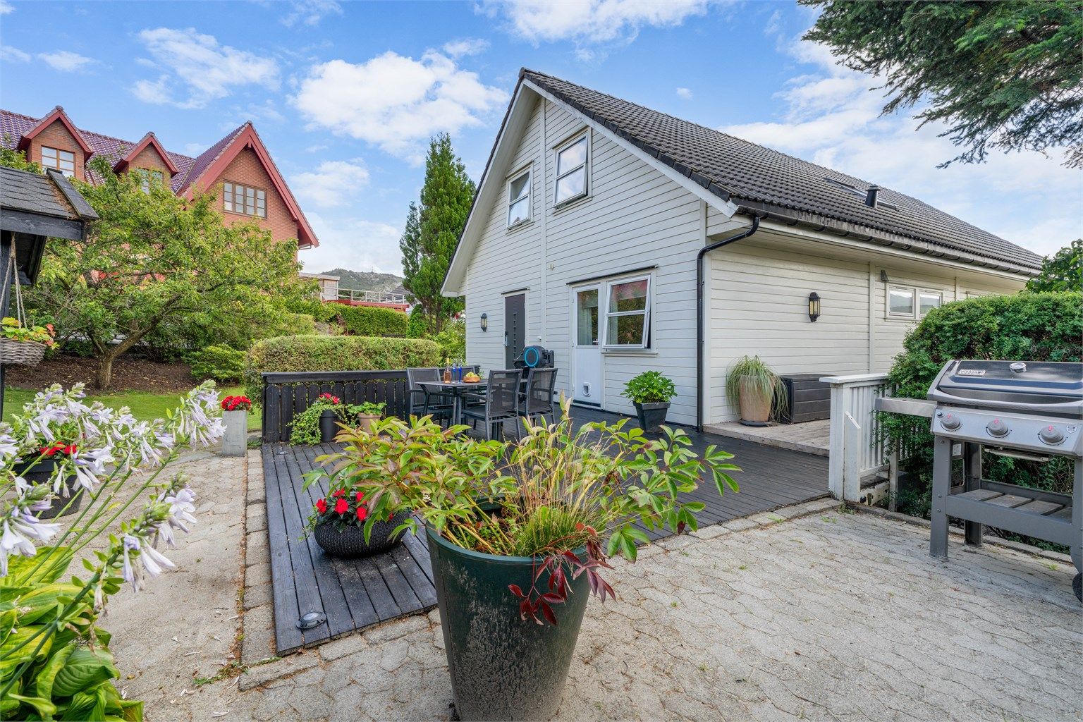 Tomten er pent opparbeidet med flere uteplasser og grøntarealer.