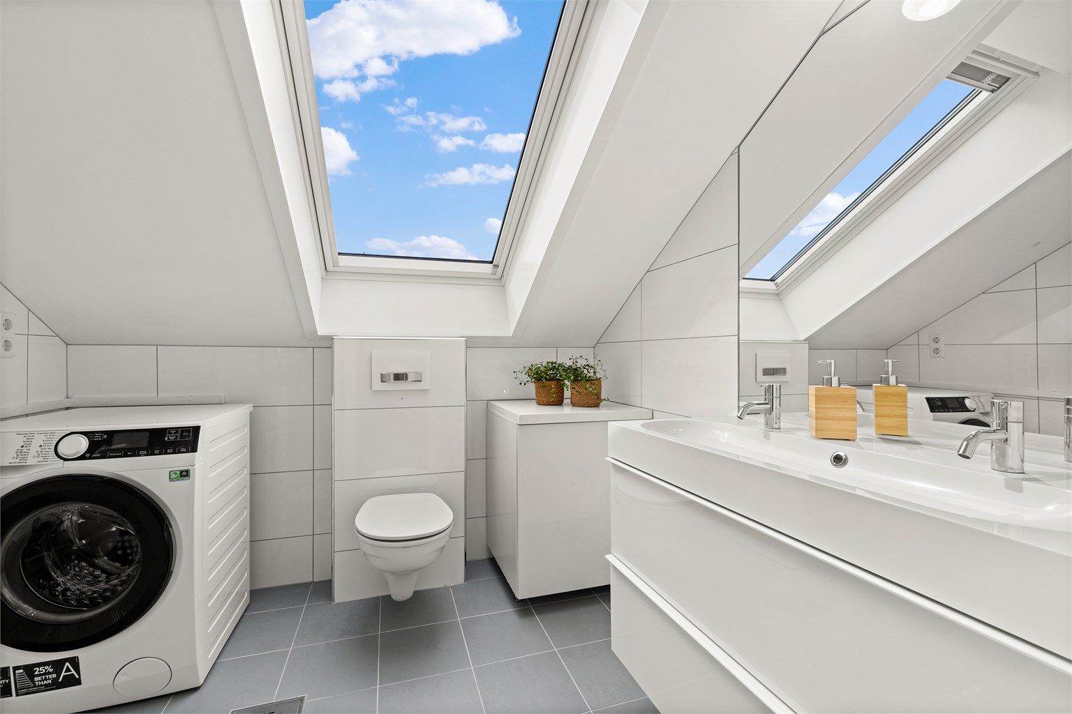 Leilighetens andre bad er romslig, med takvindu, gulvvarme og opplegg for vaskemaskin.