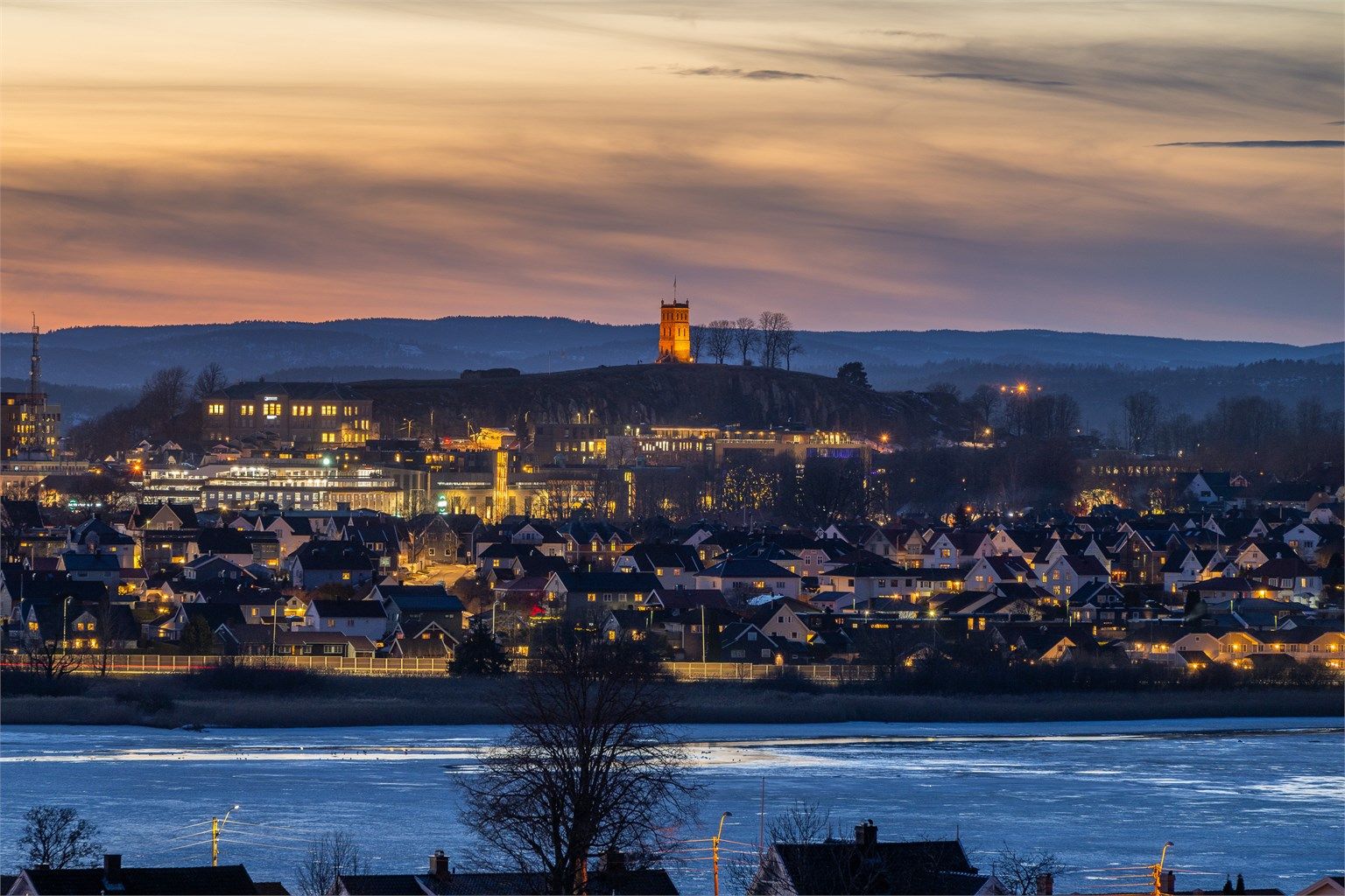 Magisk kveldspanorama med utsikt over fjorden og byens lys.