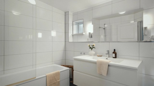 Helfliset bad med varmekabler fra byggeår som er innredet med baderomsmøbler, badekar med dusjvegg og vegghengt wc