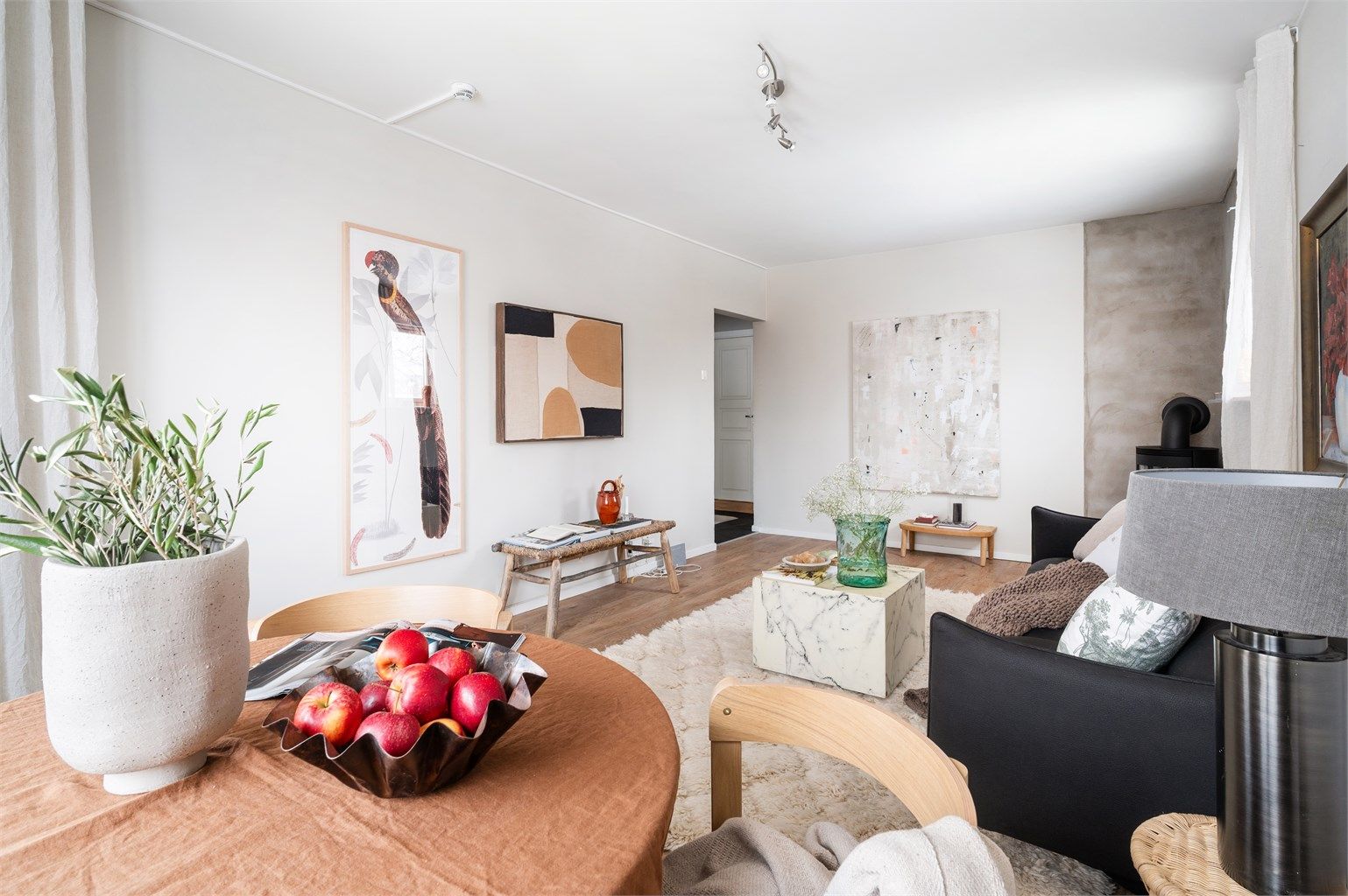 Den åpne følelsen mellom spiseplass og stue skaper et sosialt og innbydende rom.