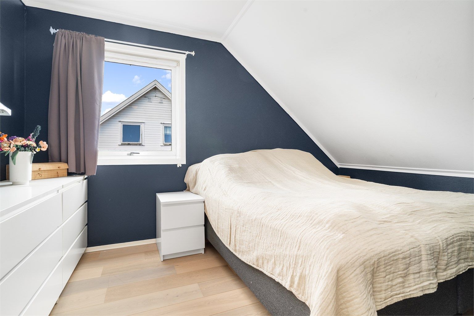 Hovedsoverom med plass til dobbeltseng og oppbevaringsmøbler.