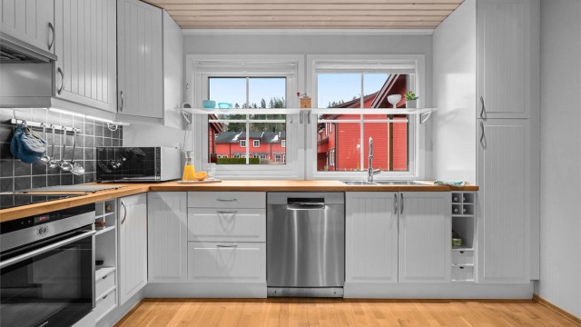 Kjøkkenet er utstyrt med rikelig skapplass og smarte oppbevaringsløsninger, inkludert vinhyller.