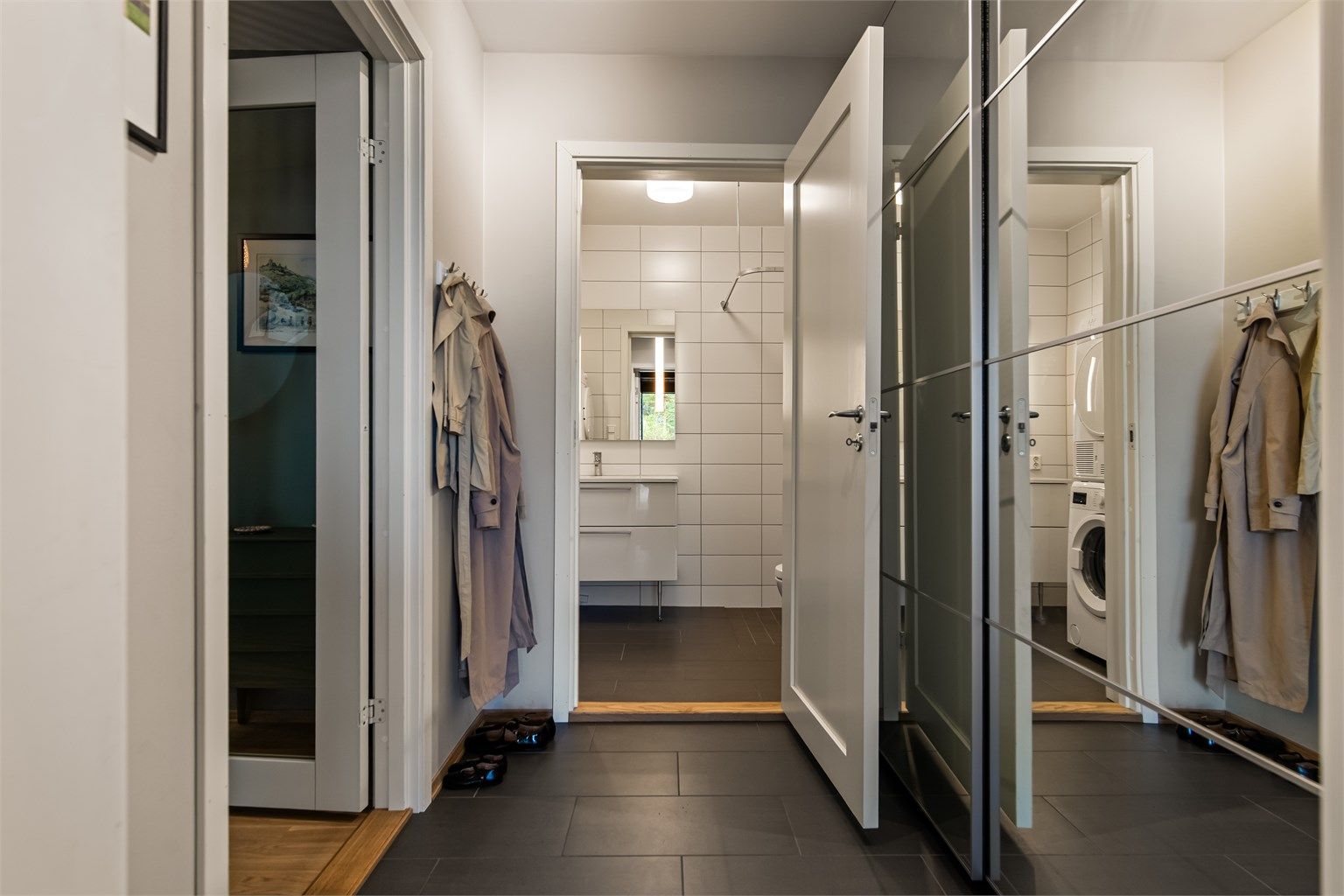 Entréen har flislagt gulv, varmekabler og speilskyvedørsgarderobe.
