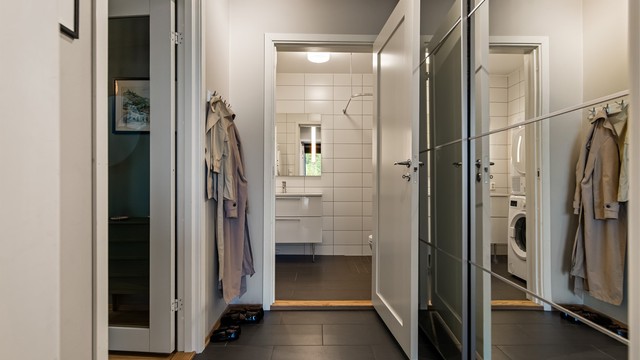 Entréen har flislagt gulv, varmekabler og speilskyvedørsgarderobe.