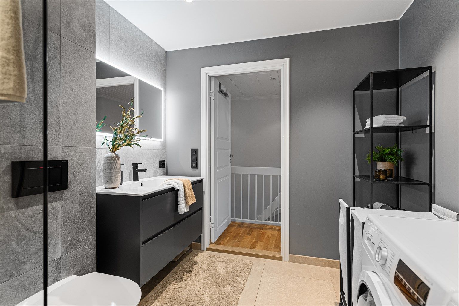 Servant med skuffer og stort speil på vegg.