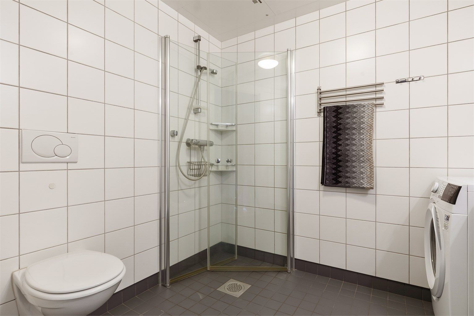 Flislagt bad med gulvvarme. Innredet med dusjhjørne med innfellbare dører og vegghengt toalett