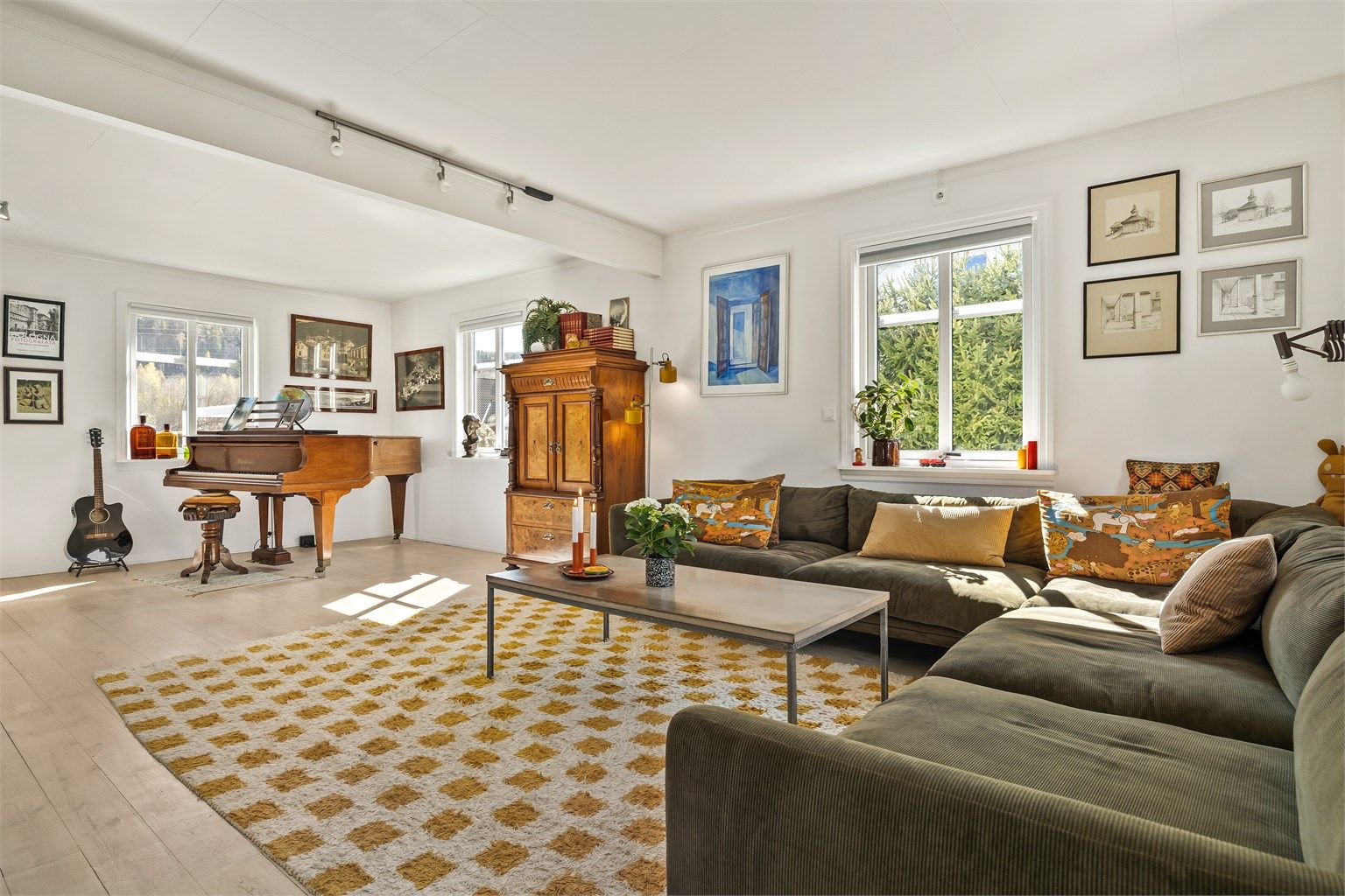 Hovedstuen er romslig og har plass til flere sittegrupper. Rommet har heltre gulvbord og store vindusflater.