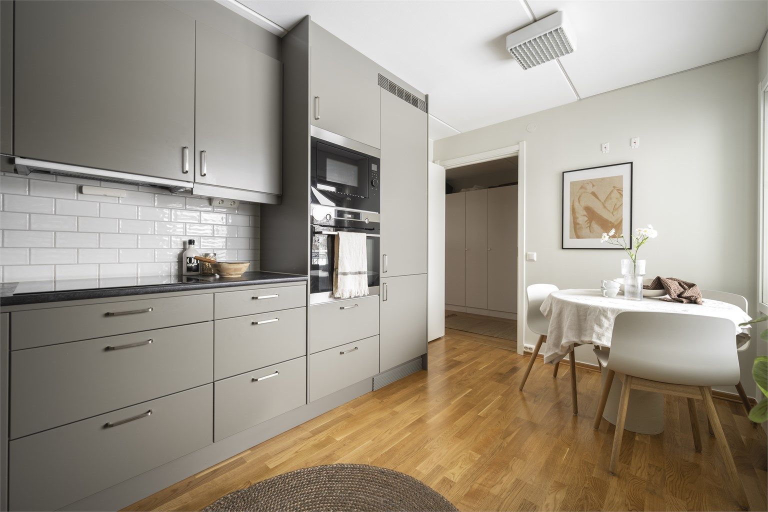 Moderne kvalitetskjøkken med integrerte hvitevarer og hyggelig spiseplass ved vinduet.