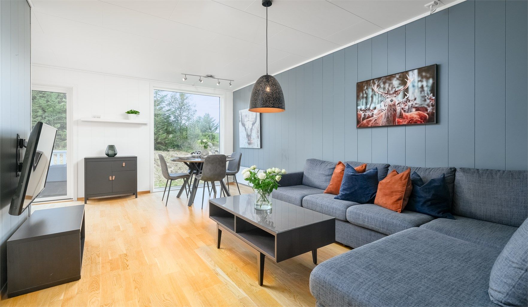 Trivelig stue med store vindusflater som slipper inn rikelig med dagslys og gir flott utsyn mot grønne omgivelser.