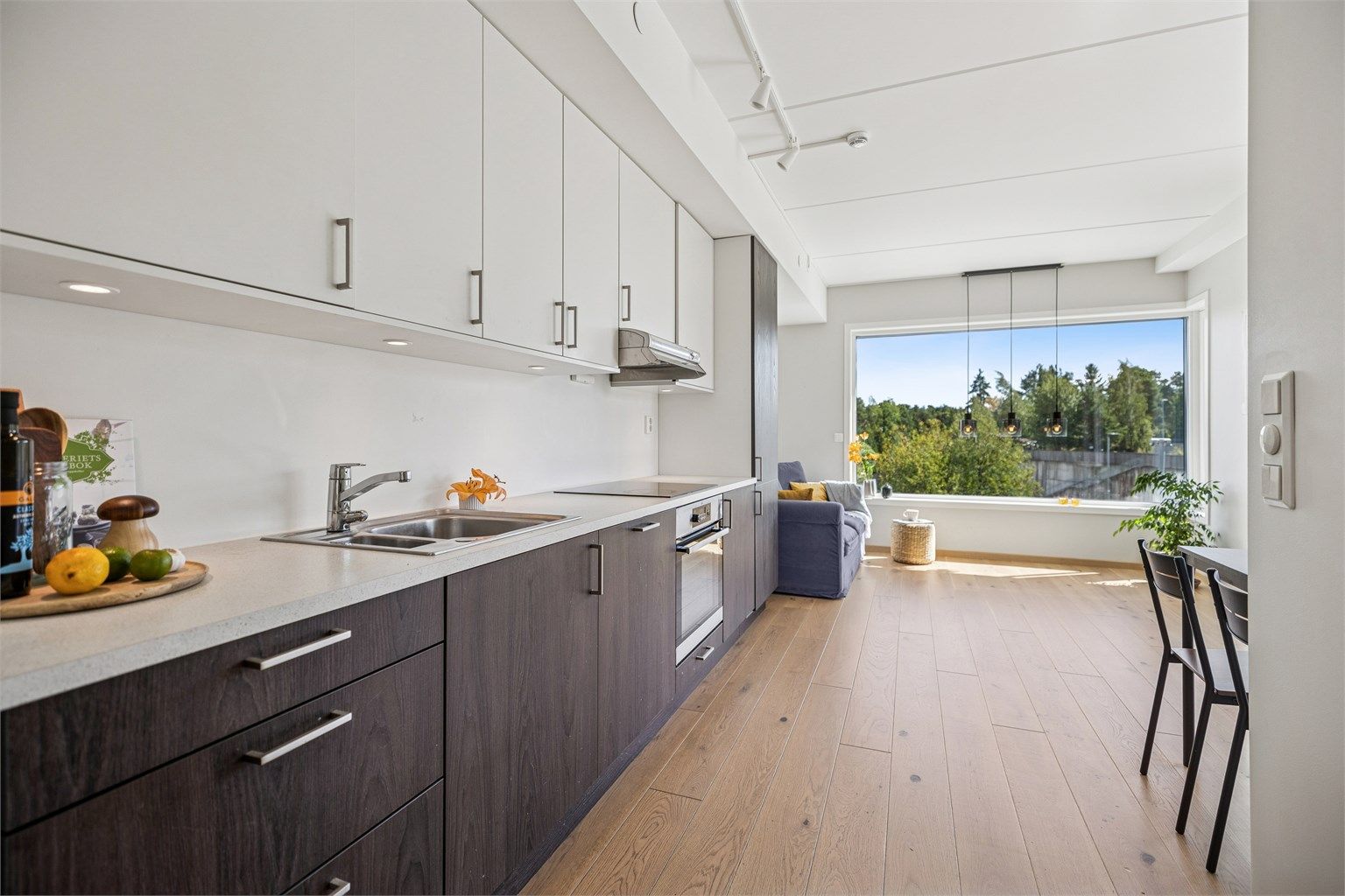 Pent og funksjonelt kjøkken med åpen løsning mot stue og spisestue, noe som skaper en sosial og luftig romfølelse.