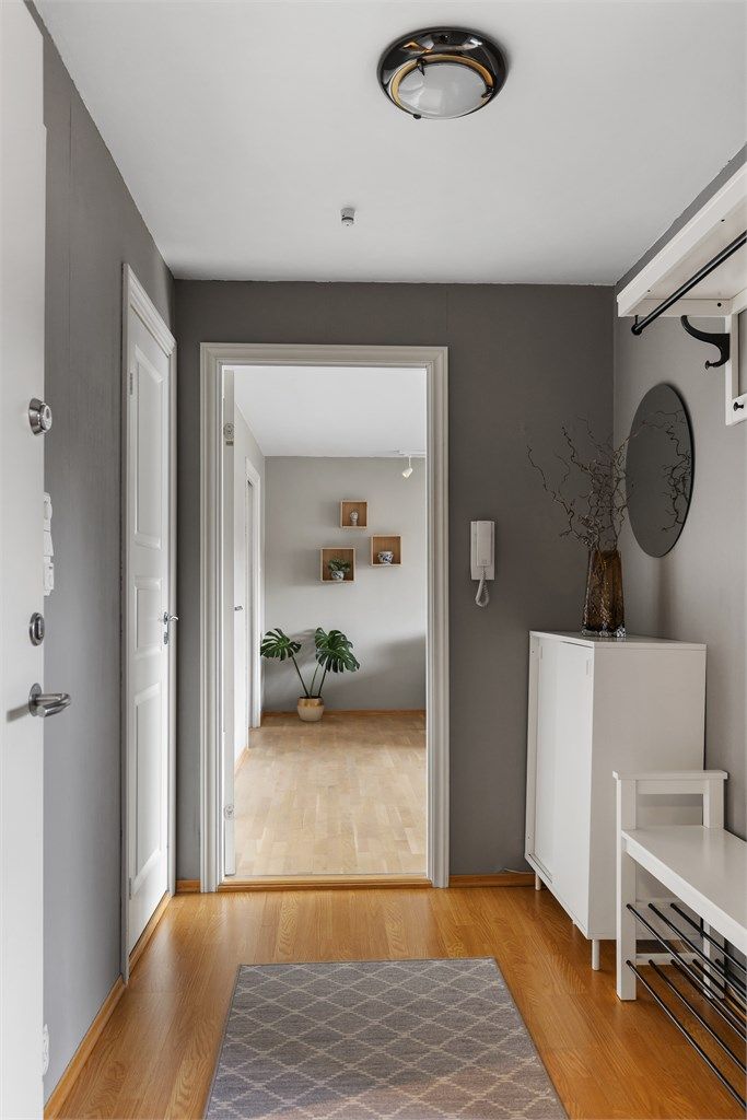 En lys og innbydende entré med plass til oppbevaring av yttertøy og sko. Dørcalling med portåpner gir enkel og trygg adkomst for deg og dine gjester.