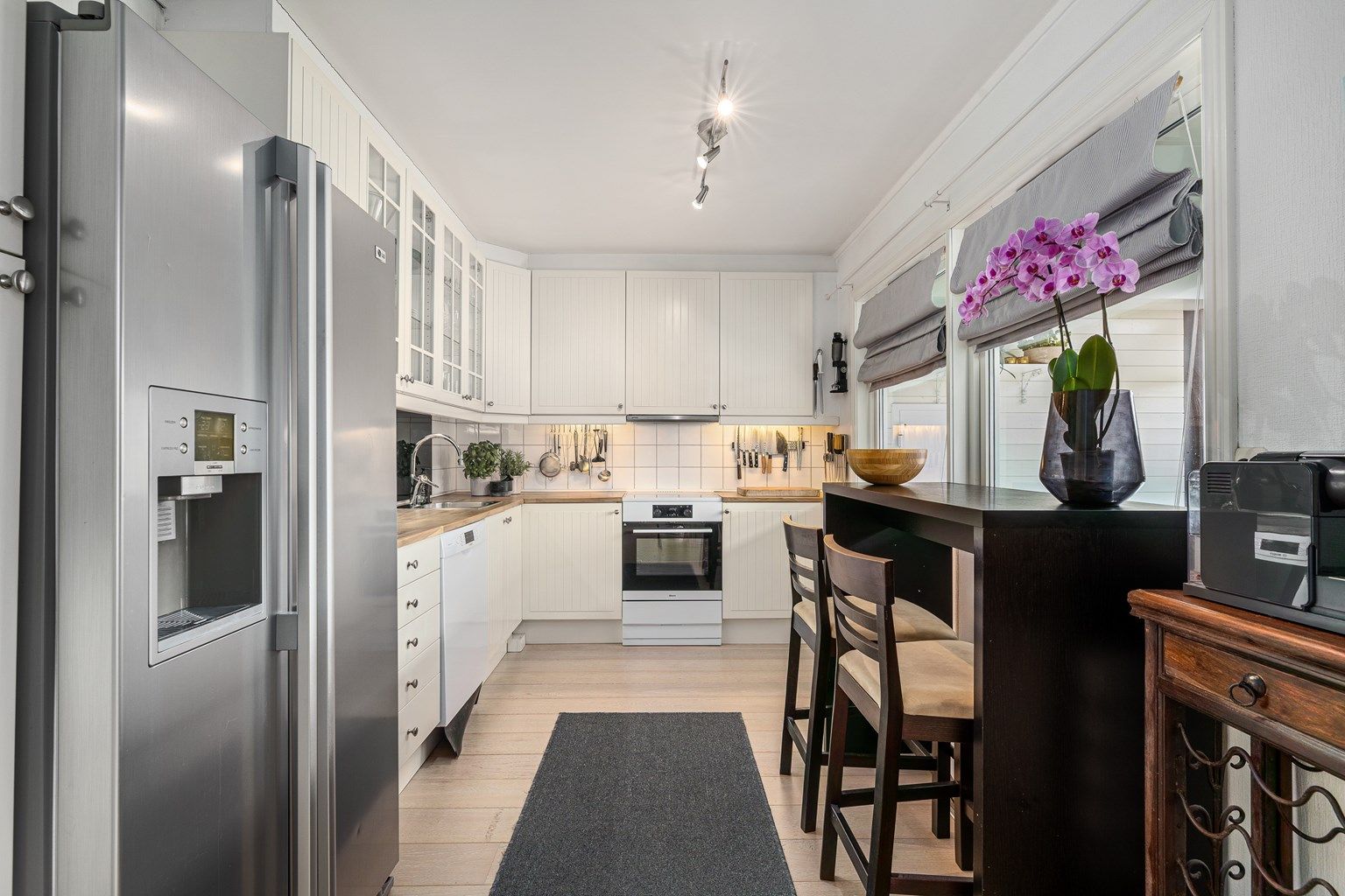 I delvis åpen løsning fra stuen finner du et lyst kjøkken med profilerte fronter