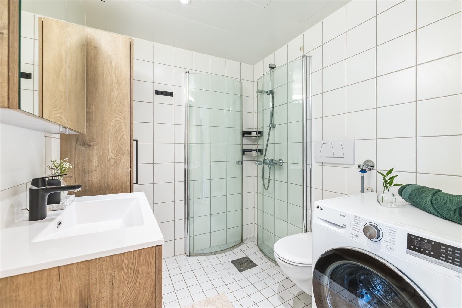  Badet har vegghengt servantinnredning med ovenpåliggende servant, speilskap med overlys samt vegghengt baderomsmøbel og toalett. Eget dusjhjørne med innfellbare glassdører. Det er opplegg for vaskemaskin og i tillegg plass til tørketrommel.