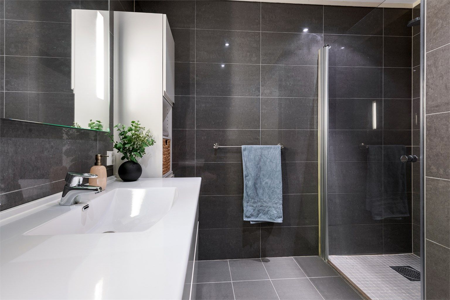 Baderomsinnredningen gir gode oppbevaringsmuligheter i skuffer og høyskap.