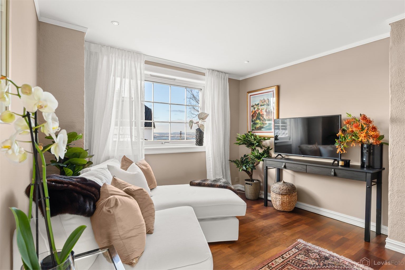 Lys og hyggelig tv-stue med fjordutsikt