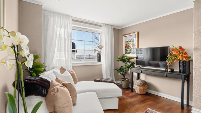 Lys og hyggelig tv-stue med fjordutsikt