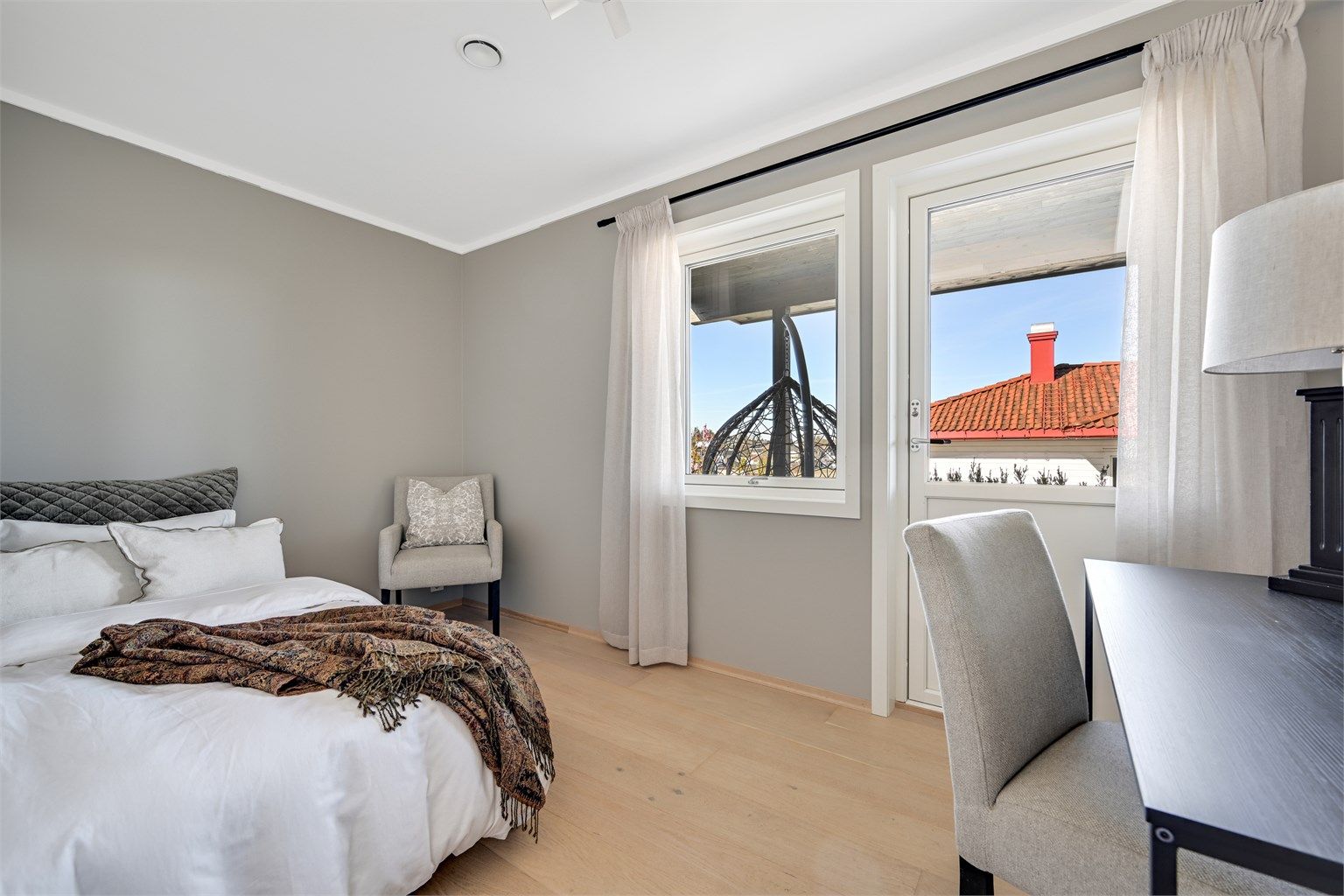 Et av to soverom i første etasje, med parkett på gulv og malte veggflater.