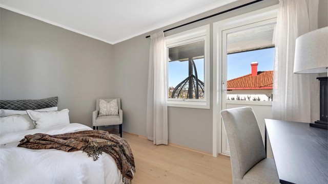 Et av to soverom i første etasje, med parkett på gulv og malte veggflater.