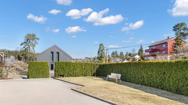 Tomten er pent opparbeidet med felles plenareal foran huset mot Storåsveien, fjell i dagen og asfaltert oppkjørsel og gårdsplass. Egen parkeringsplass i tillegg til garasjen