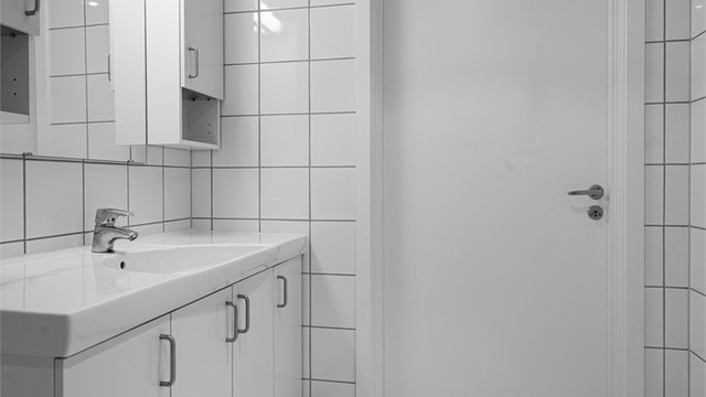 Heldekkende servant over servantskap i hvit og glatt utførelse. Tilsvarende utførelse på vegghengte skap med hyller.