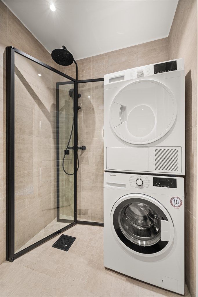 Praktisk dusjhjørne med regnfallsdusj og innfellbare glassdører, samt opplegg for vaskesøyle.