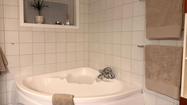 Hjørnebadekar på bad i underetasjen med badekarsarmatur. Bilde tatt av selger