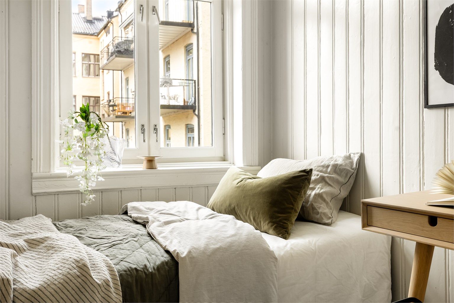 Stor vindusflate i kombinasjon med takhøyden gir rommet en lys og luftig atmosfære.