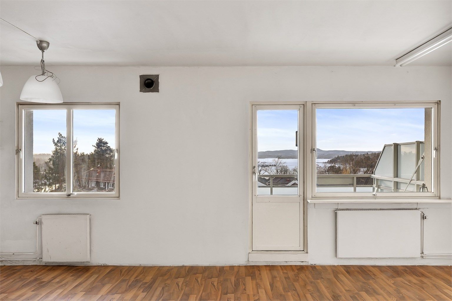 Store vinduer og dør til balkongen slipper inn rikelig med dagslys i hovedrommet.