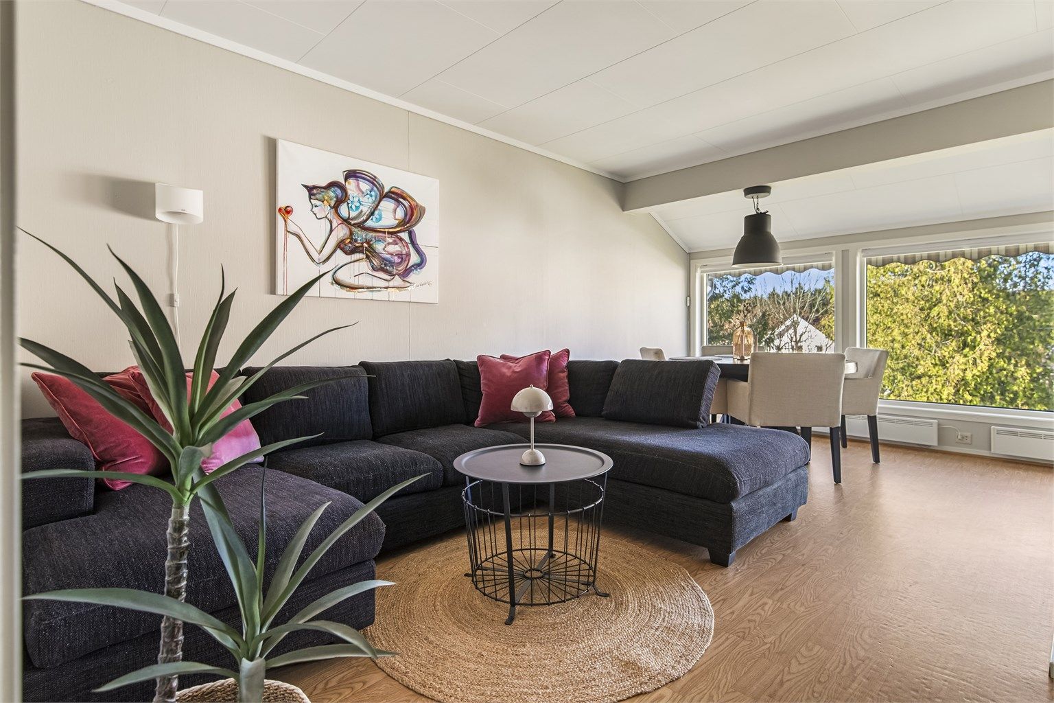 Koselig og lys stue med store vindusflater som gir rommet naturlig lys