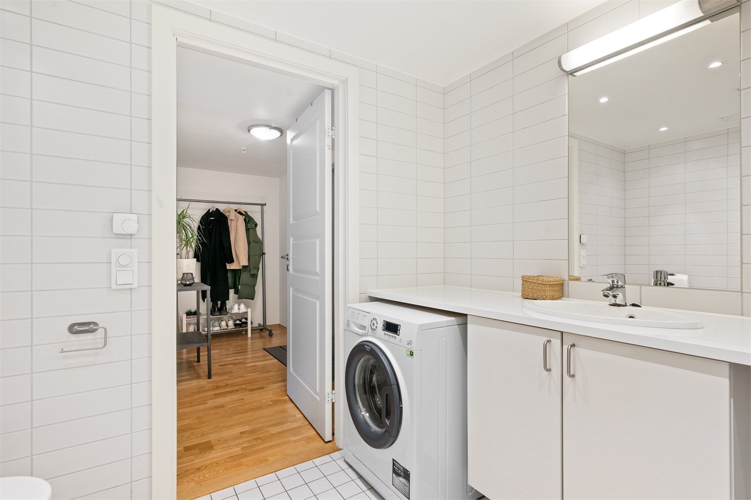 Veggmontert innredning med nedfelt servant og ett-greps armatur. Speil over servant, belysning og stikkontakt.