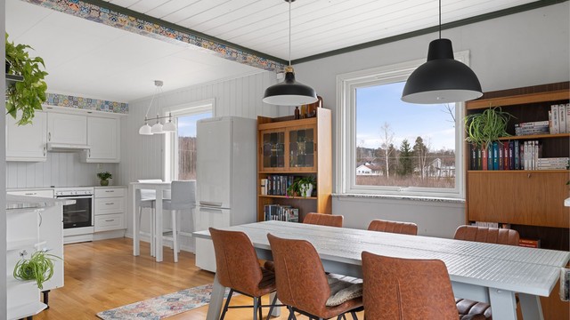 Spisestuen har plass til et stort spisebord og nyter godt av utsikten mot det omkringliggende landskapet.