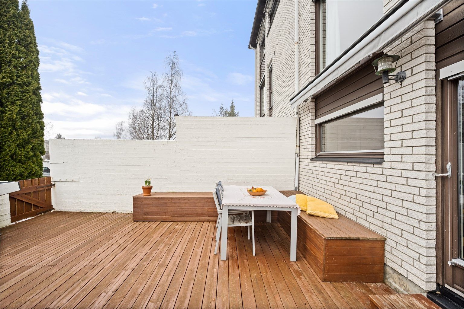 Terrassen har plassbygde benker med plass til oppbevaring i benkene.