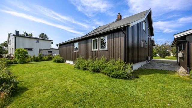 Tomten er opparbeidet med plenarealer og diverse beplantning.