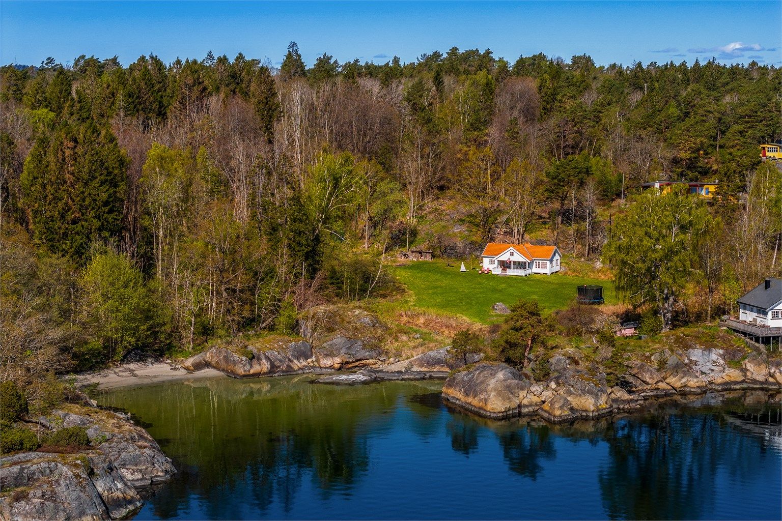 Hytta ligger fint for seg selv med gresslette som strekker seg ned mot sjøen med sandstrand og svaberg.