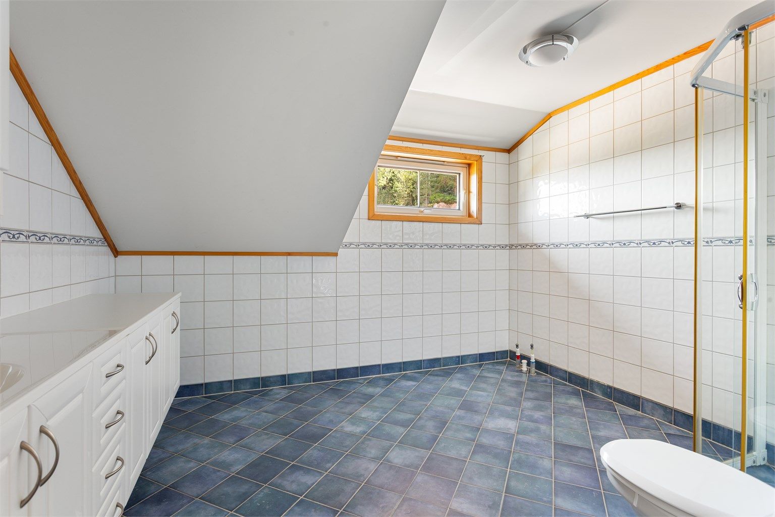Badet har skråtak og et vindu som gir godt med dagslys.