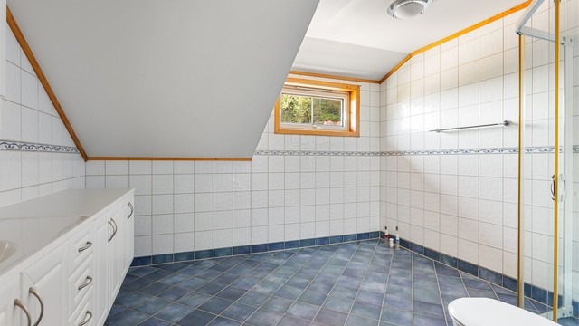 Badet har skråtak og et vindu som gir godt med dagslys.