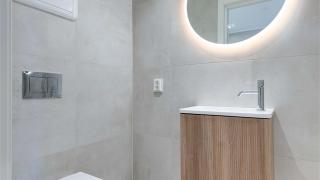 Badet i første etasje er oppgradert i 2026, med vegghengt toalett, baderomsmøbler og speil med sidelys.