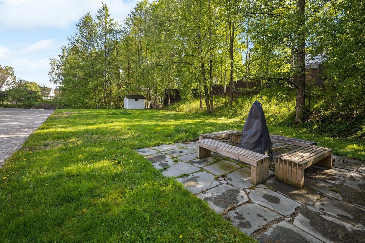 Hyggelig fellesområde med grønn gressplen og grillplass – perfekt for avslappende dager ute og hyggelige sammenkomster i grønne omgivelser.