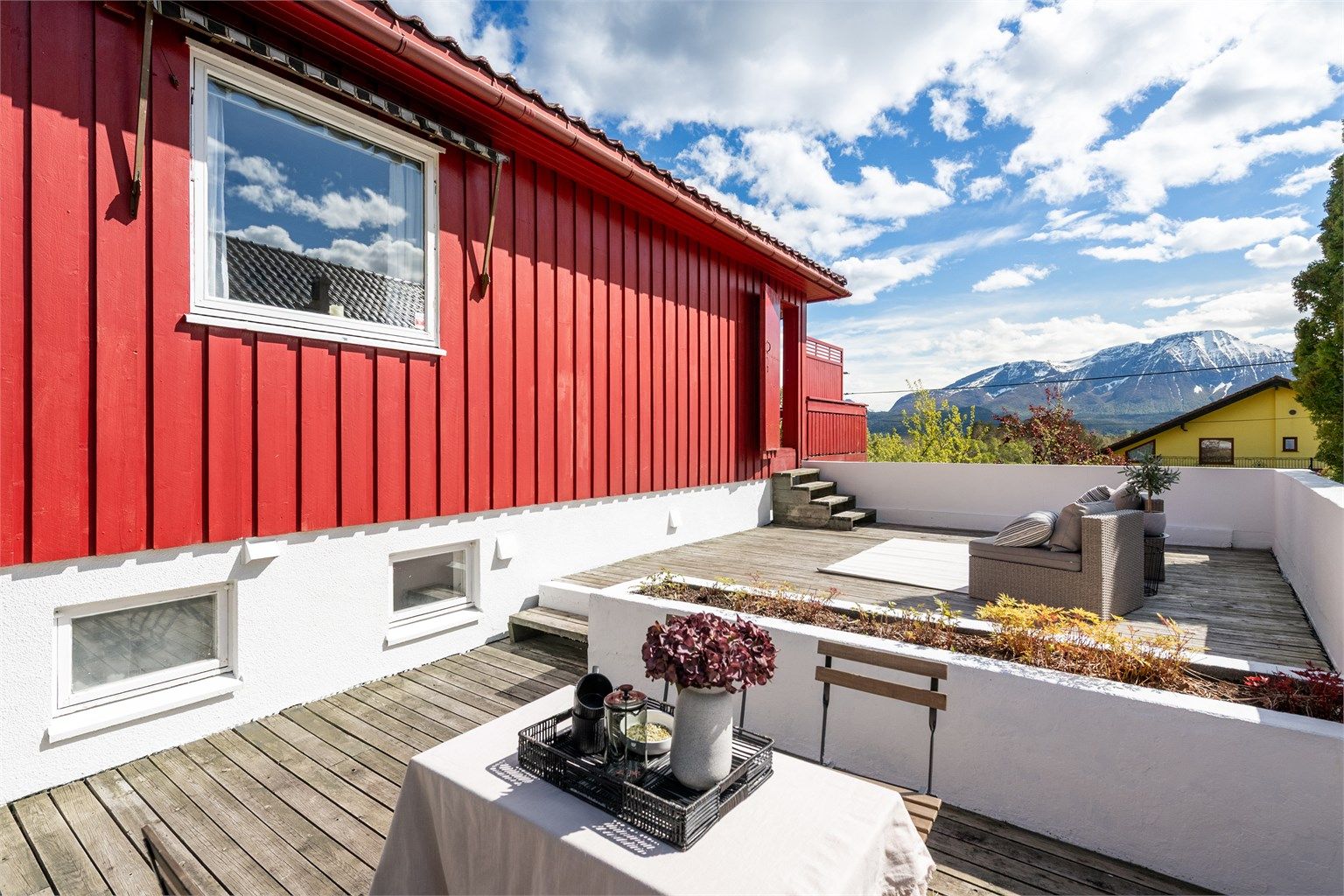 Terrassen mot vest har tredekke og murrekkverk.