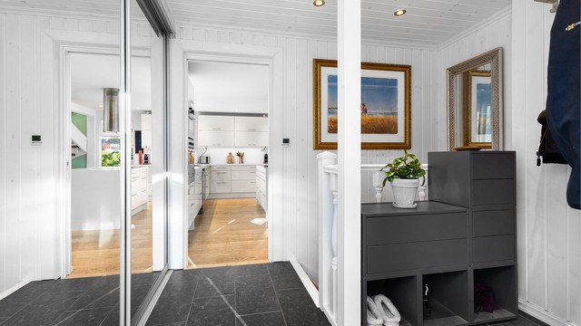 Entréen har flislagt gulv med varme, downlights i taket og skyvedørsgarderobe med speil.