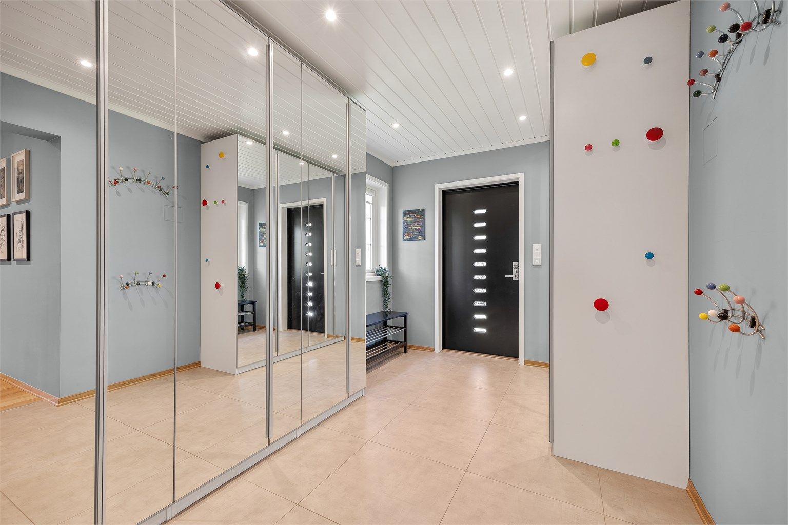 Boligen har en stor og innbydende entré med god plass til oppbevaring av sko og yttertøy i to store praktiske garderobeskap med speilfronter.
